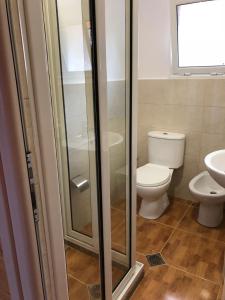 a bathroom with a toilet and a glass shower at The Mussel House in Ksamil