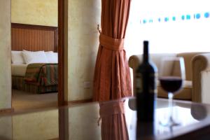 Una botella de vino sentada en una mesa en un dormitorio en Park Hotel Calama, en Calama