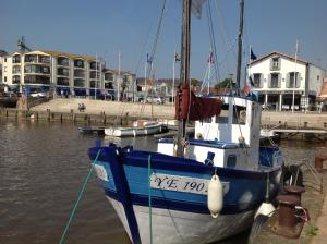 a blue and white boat is docked in the water at L'appart des lutins in Pornic