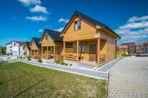 rząd drewnianych domów na podwórku w obiekcie Na Slonecznym Wzgorzu we Władysławowie