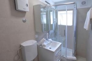 萨拉热窝Deluxe Bellevue Apartments的浴室里有马桶、洗手池和淋浴。 更多66张照片