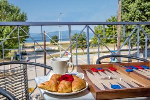 a table with a plate of croissants and a cup on a balcony at Golden Suites in Ofrínion