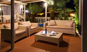 a patio with two couches and a coffee table at Hotel Corallo in Pomonte