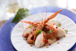 a plate of food with shrimp on a table at Hotel Corallo in Pomonte