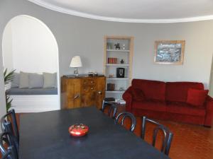 un soggiorno con tavolo e divano rosso di La MAISON du PORT a Marsiglia
