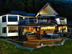 a house with a large deck with a porch at Twin Peaks Villa in Nelson