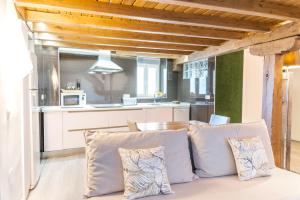 a living room with a couch and a kitchen at PINTORES ROOMS Apartamentos Turísticos in Cáceres