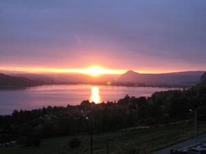 a sunset over a body of water at Le Clos Du Lac - location de chambres in Veyrier-du-Lac