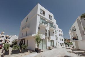 a white building with potted trees in front of it at River View Boutique Apts in Ayia Napa