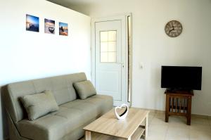 a living room with a couch and a tv at Sky-Line Apartments in Afantou