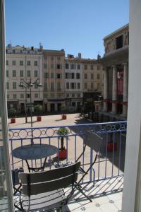 a balcony with a table and chairs on a city street at La MAISON de l'OPERA in Marseille
