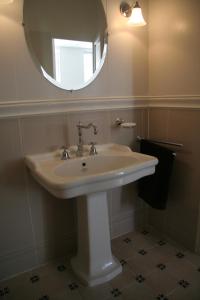 La salle de bains est pourvue d'un lavabo blanc et d'un miroir. dans l'établissement La MAISON de l'OPERA, à Marseille