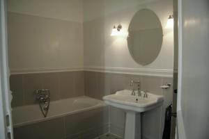 La salle de bains est pourvue d'un lavabo, d'une baignoire et d'un miroir. dans l'établissement La MAISON de l'OPERA, à Marseille