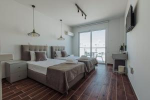 a bedroom with two beds and a large window at River View Boutique Apts in Ayia Napa +34 photos
