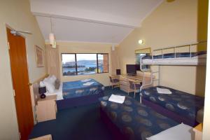 a hotel room with two bunk beds and a desk at Alpine Resort Motel in Jindabyne