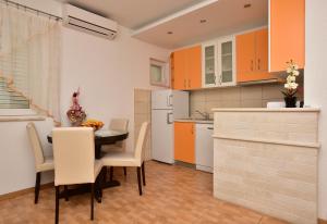a kitchen with a table and chairs and orange cabinets at Apartment Markus in Makarska +17 photos
