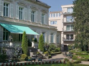 a building with a green awning next to a courtyard at Hotel Belle Epoque in Baden-Baden