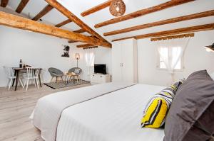 1 dormitorio blanco con 1 cama y comedor en Casa Mulino, en Rovinj