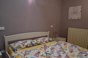 a bedroom with a bed with a comforter on it at Il Melograno b&b Apartament in Roe +18 photos