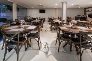 a dining room with wooden tables and chairs at Days Inn by Wyndham Linhares in Linhares