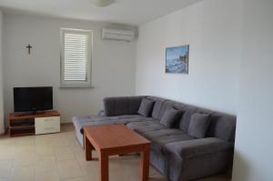 un soggiorno con divano e tavolo di Apartments Buljan a Baška