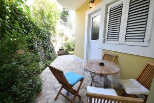 un patio con tavolo, sedie e finestra di Huter Apartments a Herceg-Novi