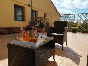 une terrasse avec des chaises et une table avec des boissons. dans l'établissement "Profumo di Tiglio", à Bagnoregio