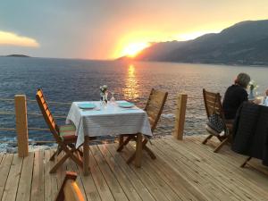 a table on the deck of a boat with the sunset at Mandalina Suites in Kaş