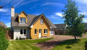 a house with a yellow and gray roof at Hector's House in Aviemore