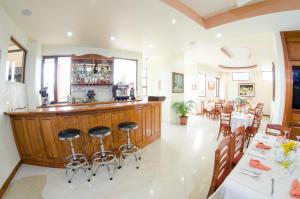 a restaurant with a bar with tables and chairs at Hotel Anna Inn in Olintepeque