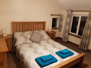 a bedroom with a bed with two blue towels on it at yew tree cottage in Hereford