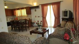 a living room with a couch and a table and a kitchen at Anastasia's House in Kypseli