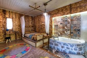 KrásionにあるKrassopsychia Apartmentsのバスルーム(バスタブ、ベッド付)