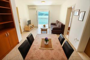 a living room with a table and chairs and a couch at Guesthouse Lamia in Neum