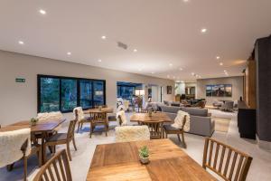 an open living room with tables and chairs at Villa Amistà Campos do Jordão in Campos do Jordão