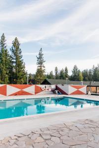 an outdoor swimming pool with an interpretive wall and trees at Noon Lodge in Big Bear Lake
