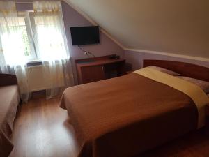 a bedroom with a bed and a desk and a television at Janina in Pobierowo