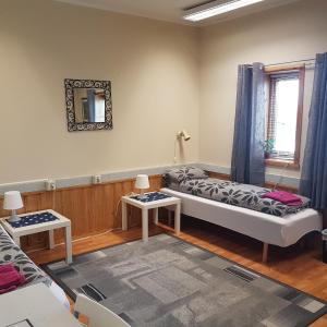 Sala de estar con 2 camas y 2 mesas en Wilhelmsen Romutleie en Vardø