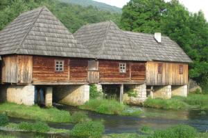 una vecchia casa di legno sulla riva di un fiume di Apartman Antea a Otočac