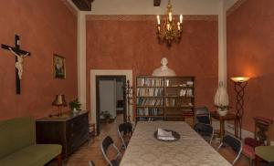 a living room with a table and a cross on the wall at Casa Diocesana di Lucca in Lucca