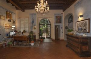 a large living room with a chandelier and a desk at Casa Diocesana di Lucca in Lucca