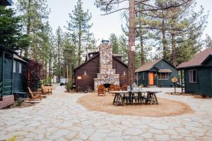 a patio with tables and chairs in front of a cabin at Noon Lodge in Big Bear Lake