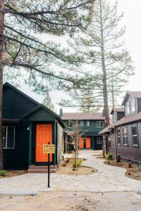 a house with an orange door and a sign in front of it at Noon Lodge in Big Bear Lake