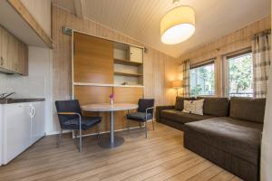 a living room with a couch and a table and chairs at Undinėlė in Šventoji