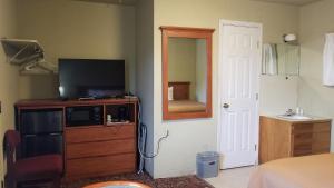a bedroom with a tv and a dresser with a television on it at Quick Stop Motel in Round Prairie