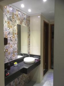 W łazience znajduje się umywalka i lustro. w obiekcie Pousada Circuito das Águas w mieście Caxambu