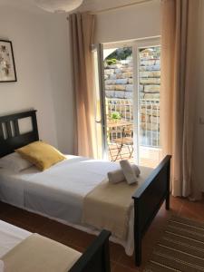 a bedroom with a bed and a view of a patio at Apartamento POR DO SOL in Aljezur