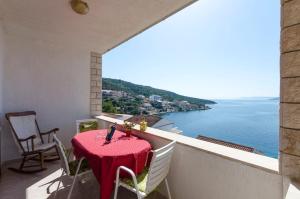 a balcony with a table and chairs and the ocean at Apartments Ante in Vinišće