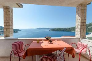 a table on the balcony with a view of the water at Apartments Ante in Vinišće