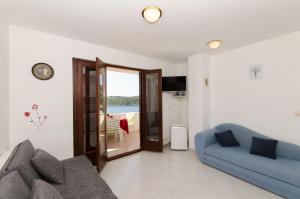 a living room with a couch and a view of the ocean at Apartments Ante in Vinišće